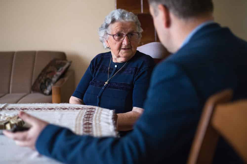Living Trust Attorney Speaking with Elderly Client