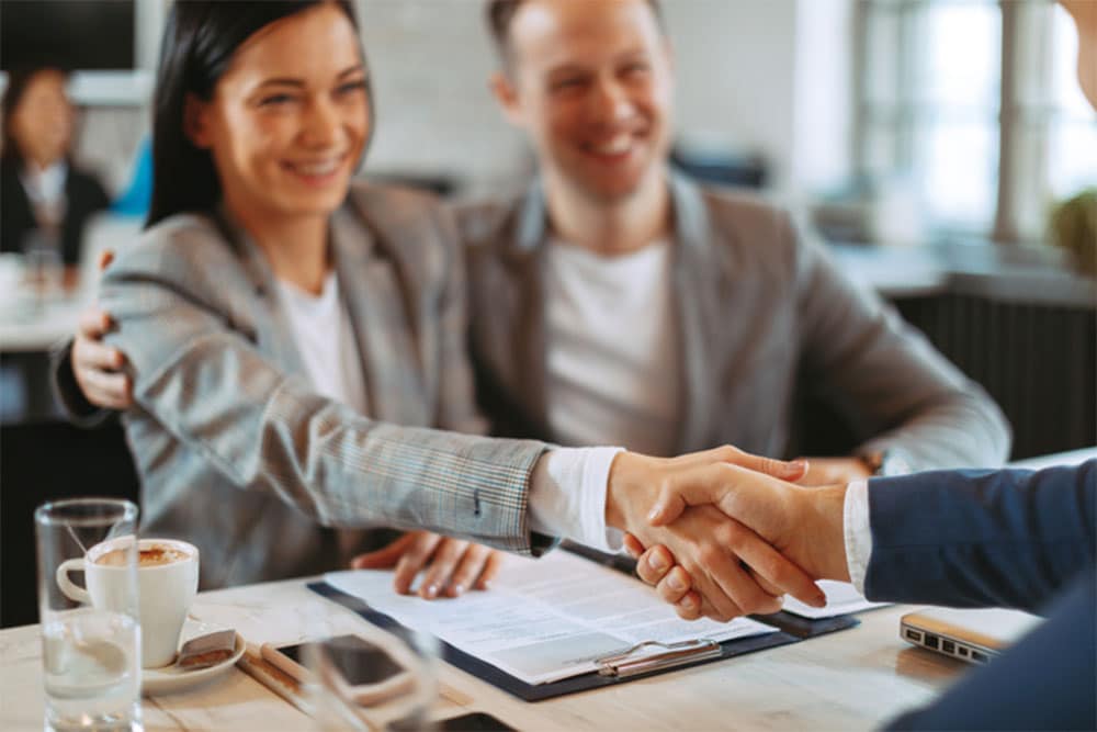 Couple Shaking Hands with Living Trust Attorney Bloomfield Hills MI