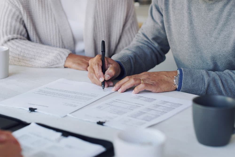 Closeup of Hands Signing with a Will and Estate Lawyer Oakland Township MI